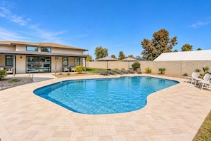 A modern house with a swimming pool, outdoor seating, and a well-maintained garden. - Charming Chandler retreat with pool, guest house, pickleball and putting green! (Chandler)