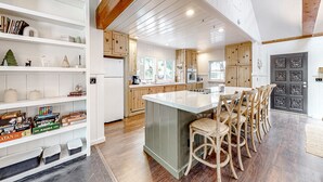A spacious kitchen with wooden cabinets, a central island, and a dining area with bar stools.