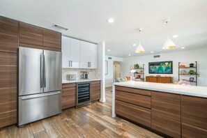 Una cocina moderna con un refrigerador de acero inoxidable, armarios de madera y una isla central.