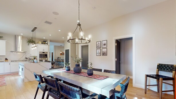 A spacious kitchen with a central island, modern appliances, and a chandelier. - Updated luxury home with ensuite bedrooms, fireplace, & large deck w/ firepit (Flagstaff)