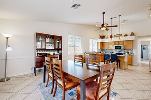 A spacious kitchen with a central island, wooden cabinets, and a dining area with a large table and chairs. - Scottsdale Oasis – Poolside Paradise Near Golf, Shopping & Freeways! (Scottsdale)