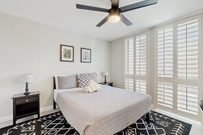 A bedroom with a bed, a nightstand, a ceiling fan, and a window with blinds. - Your perfect Scottsdale escape with a private pool, spacious layout, and parking (Scottsdale)