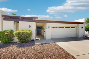 A modern house with a garage, a well-maintained driveway, and a clear sky. - Your perfect Scottsdale escape with a private pool, spacious layout, and parking (Scottsdale)