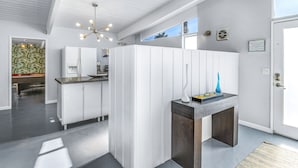Een moderne keuken met witte kasten, een granieten werkblad en een bijzondere lamp.