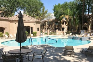 A swimming pool with lounge chairs and umbrellas, surrounded by buildings with a tiled roof. - North Scottsdale Retreat | Ground-Level Condo, Resort Amenities & Prime Location (Scottsdale)