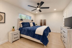 A bedroom with a bed, a ceiling fan, a TV, and a nightstand. - Modern Comfort & Desert Fun—A Chic Two-Story Home Base Minutes From Everything. (Scottsdale)