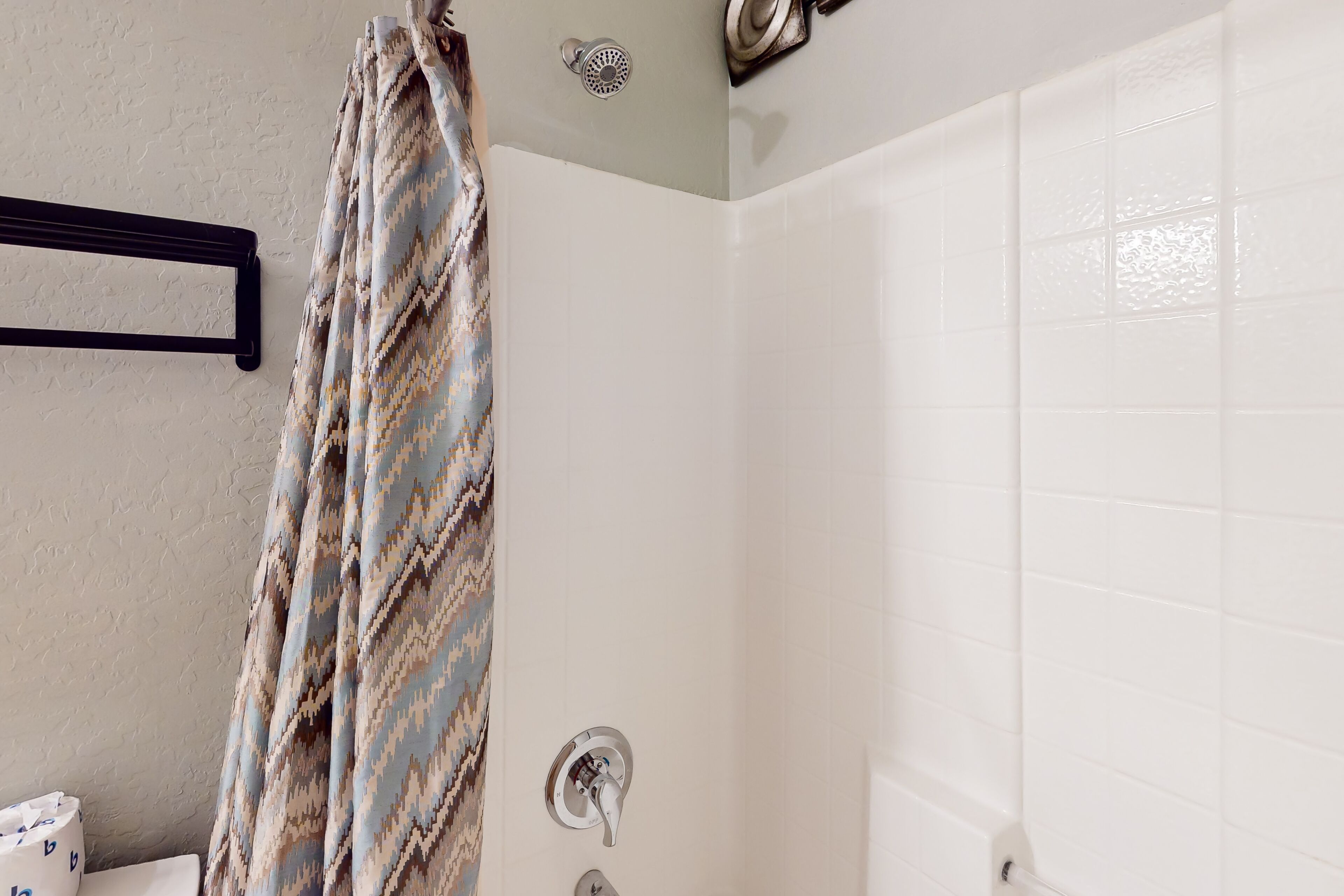Un baño con ducha, toallero y retrete.