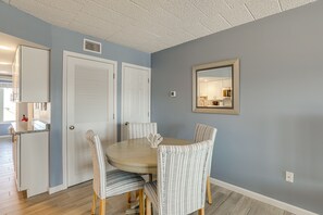 A dining area with a round table, four chairs, and a wall-mounted mirror. - Oceanside Retreat in Mantoloking: Walk to Beach! (Mantoloking)
