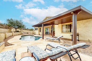 A backyard with a swimming pool, lounge chairs, and a covered patio area. - Dreamy desert gem with private pool, firepit, grill, lanai & AC (Goodyear)