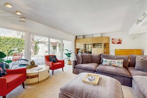 A modern living room with a sofa, armchairs, a coffee table, and a bookshelf. - Stylish Dog-Friendly Retreat W/ High-Speed WiFi, Pool & Spa, & Pool Table (Palm Springs)