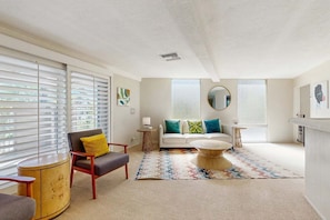 A modern living room with a sofa, armchair, coffee table, and decorative pillows. - Stylish Dog-Friendly Retreat W/ High-Speed WiFi, Pool & Spa, & Pool Table (Palm Springs)