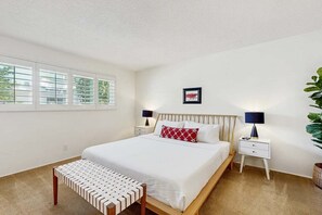 A bedroom with a bed, bedside tables, a bench, and a window with blinds. - Stylish Dog-Friendly Retreat W/ High-Speed WiFi, Pool & Spa, & Pool Table (Palm Springs)