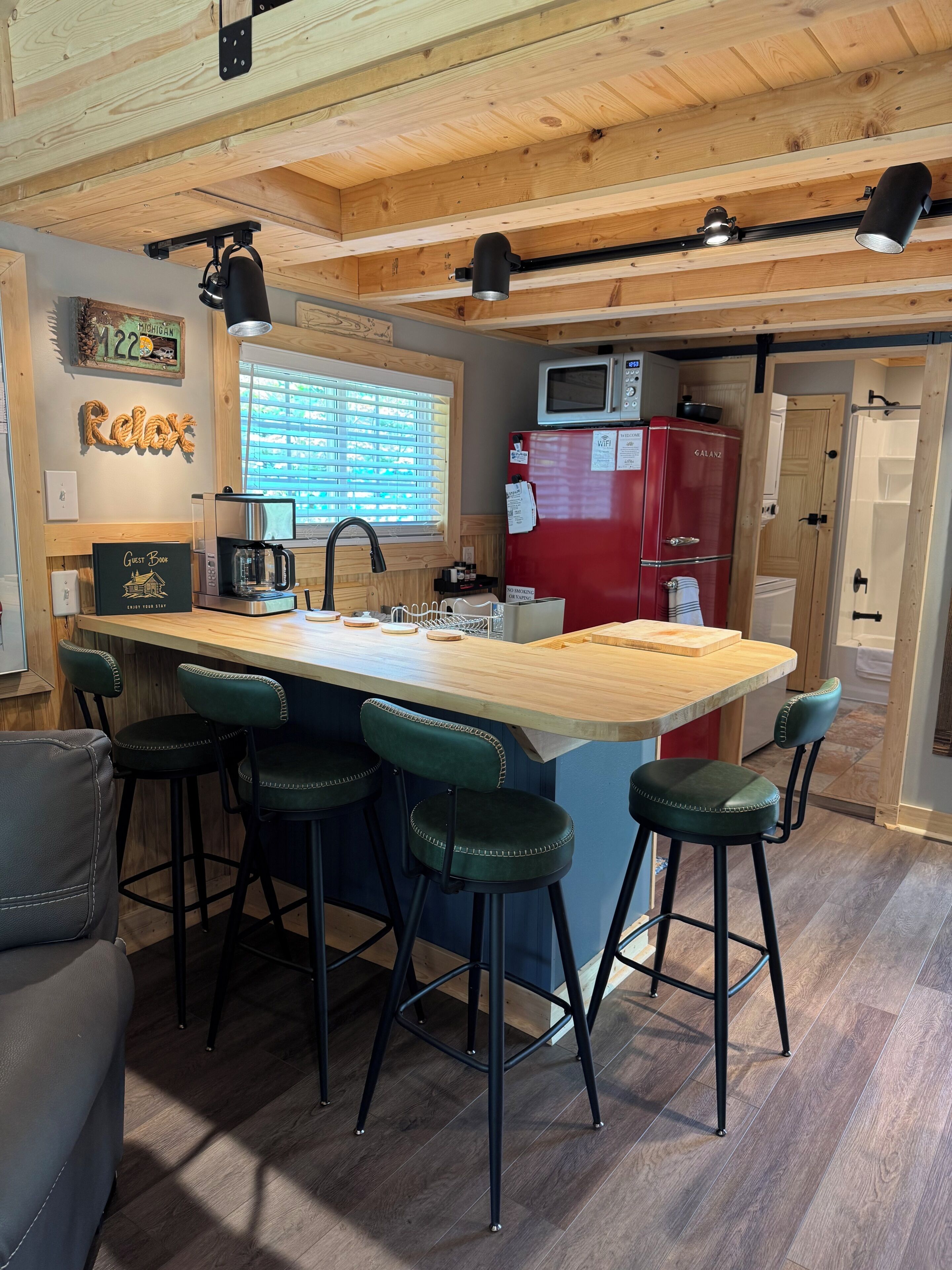 Une cuisine avec un coin bar, un plafond en bois et un réfrigérateur rouge.