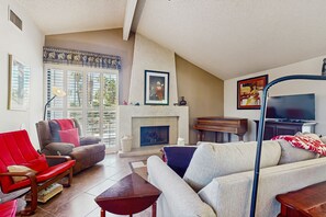 A living room with a fireplace, a television, and a sofa. - Dog-friendly home w/private pool, patio, pool spa, and gas fireplace (Palm Springs)