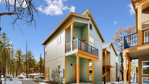 En tvåvånings bostadsbyggnad med en balkong, ett garage och en inglasad veranda.