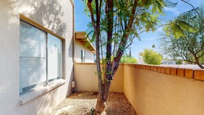 Ein Gebäudeeck mit Baum, Fenster und Mauer.