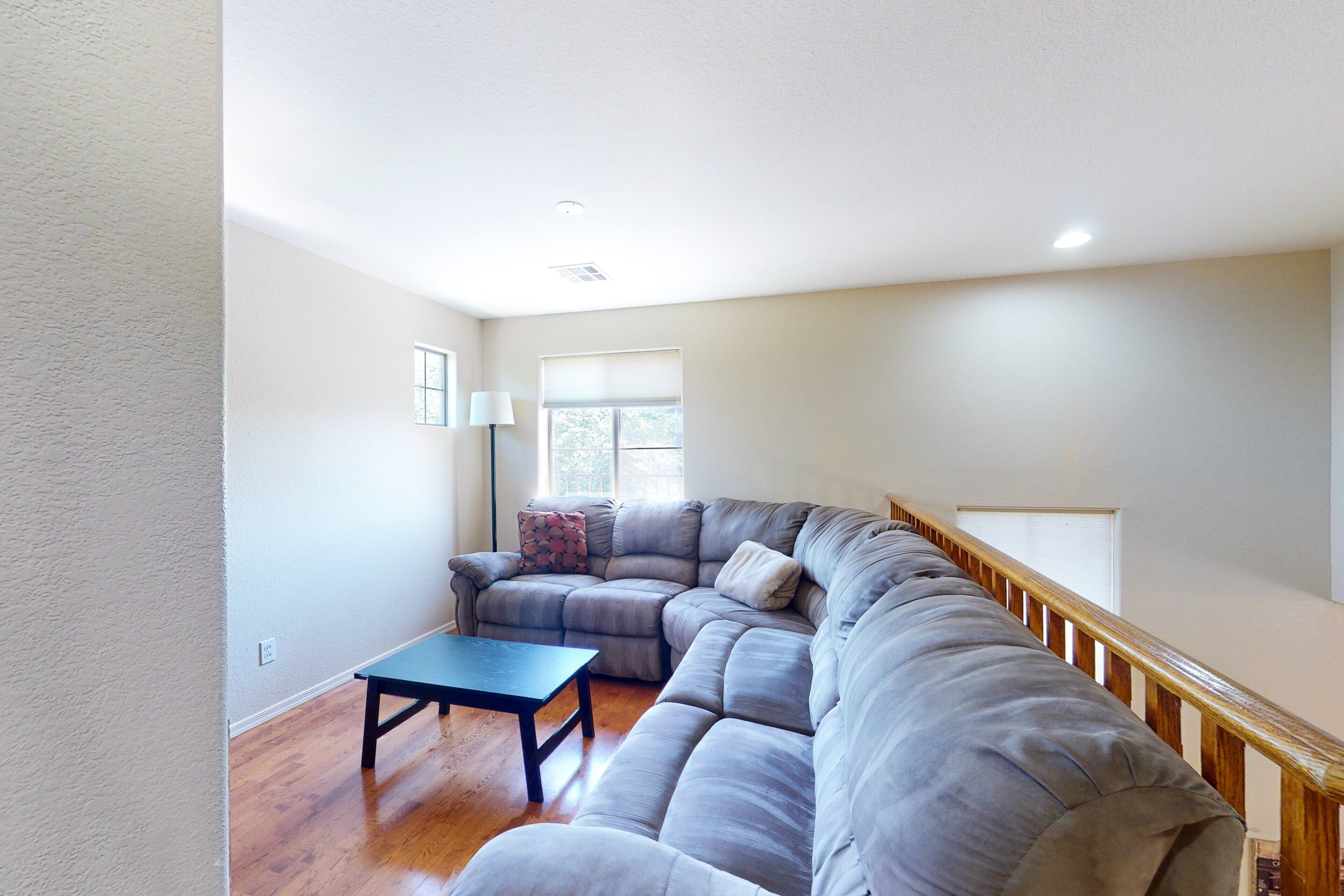 Una sala de estar con un sofá modular, una mesa de centro y una escalera.