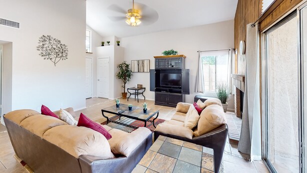 A spacious living room with a sofa set, a coffee table, and a TV stand. - Retro home with enclosed yard, covered patio, grill, firepit, AC, & washer/dryer (Glendale)