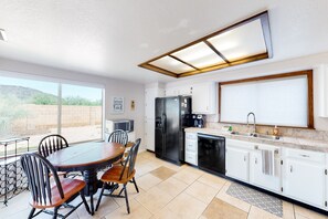 Una cocina moderna con comedor, ventanas amplias y vistas al exterior.