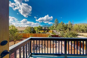 A residential area with a wooden deck, a clear sky, and houses in the background. - Spacious home w/ large yard, deck, mountain view, fire pit & grill (Flagstaff)