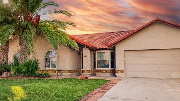 A residential house with a red-tiled roof, a garage, and a well-maintained lawn. - Charming & sunlit villa with private pool, patio, & firepit - near golf & trails (Mesa)