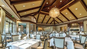 A large banquet hall with multiple tables set for dining, wooden ceiling beams, and a chandelier. - Luxury Waterfront Living! Naples Resort Condo (Naples)