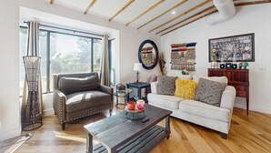 A modern living room with two sofas, a coffee table, and a large window with curtains. - Sunny downtown home with private pool, hammock, enclosed backyard, grill, patio (Phoenix)