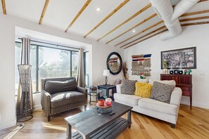 A modern living room with two sofas, a coffee table, and a large window with curtains. - Sunny downtown home with private pool, hammock, enclosed backyard, grill, patio (Phoenix)