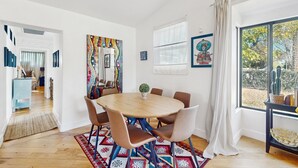 A modern dining area with a round table, chairs, and a patterned rug. - Sunny downtown home with private pool, hammock, enclosed backyard, grill, patio (Phoenix)