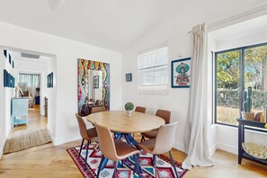A modern dining area with a round table, chairs, and a patterned rug. - Sunny downtown home with private pool, hammock, enclosed backyard, grill, patio (Phoenix)