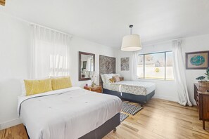 A modern bedroom with a large bed, a smaller bed, a nightstand, a dresser, and a window with curtains. - Sunny downtown home with private pool, hammock, enclosed backyard, grill, patio (Phoenix)