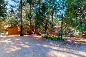 A forested area with a wooden cabin and a fenced enclosure. - Beautifully remodeled mountain home with peaceful, private setting (Idyllwild)