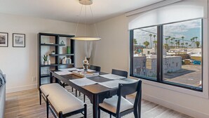 A dining area with a large window, a bookshelf, and a bench. - Indulge in Luxury and Comfort in Scottsdale, AZ where cozy meets chic (Scottsdale)