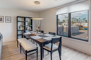 A dining area with a large window, a bookshelf, and a bench. - Indulge in Luxury and Comfort in Scottsdale, AZ where cozy meets chic (Scottsdale)