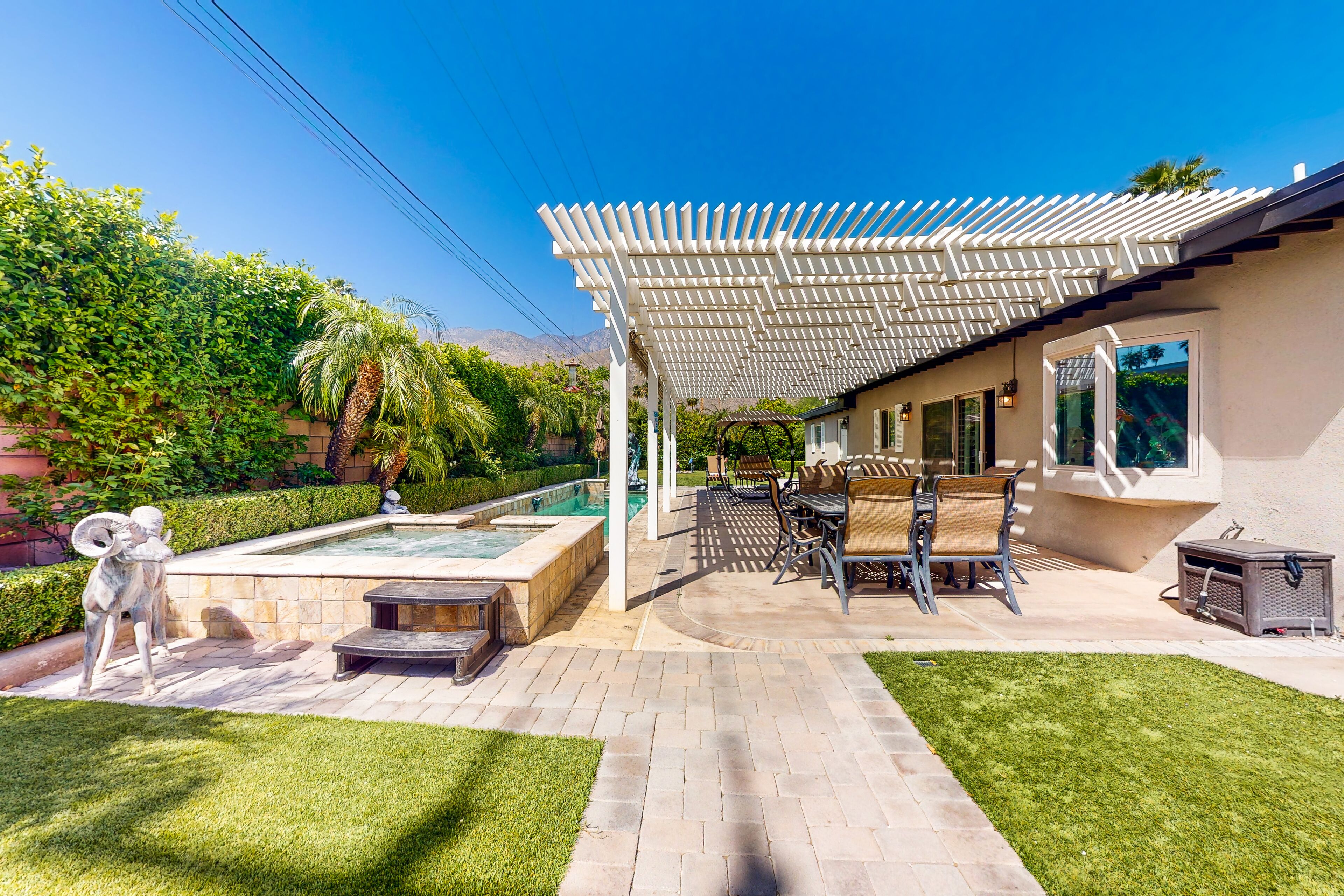 A patio area with a pool, outdoor furniture, and a pergola.