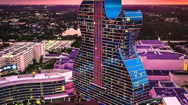 Un hôtel doté d’un bâtiment à l’architecture unique, en forme de guitare, de plusieurs piscines et d’un complexe hôtelier bien éclairé.
