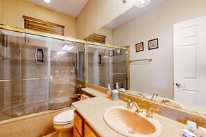 A bathroom with a large mirror, a sink, a toilet, and a shower. - Snowbird-friendly house with mountain view, pool, on-site golf, and central AC (Indio)