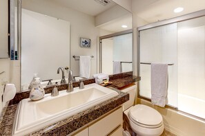 A bathroom with a sink, mirror, and toilet. - Inviting condo w/ gas grill & shared pool/spa/tennis - 1/2 block to El Paseo (Palm Desert)