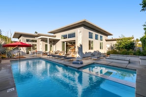 A modern two-story house with a swimming pool, outdoor seating, and a patio area. - Newly remodeled, modernist home with private pool, spa, & grill - dog-friendly (Palm Springs)