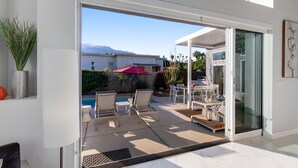 Eine moderne Terrasse mit Pool, Gartenmöbeln und Bergblick.