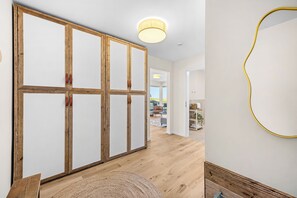 A room with a wooden wardrobe, a round mirror, and a view to a balcony. - The View B04 Briese - Garden furniture, elevator, shared Sauna, parking space (Dagebüll)