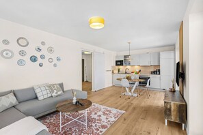 A modern apartment with a living room, kitchen, and dining area. - The View B04 Briese - Garden furniture, elevator, shared Sauna, parking space (Dagebüll)