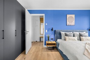 A bedroom with a bed, bedside table, and a wardrobe. - The View B12 Zuhause bei Emi -Sea view,elevator, balcony, armchair, shared Sauna (Dagebüll)
