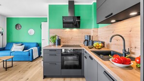 A modern kitchen with a built-in oven, a coffee machine, and a sink. - The View B12 Zuhause bei Emi -Sea view,elevator, balcony, armchair, shared Sauna (Dagebüll)