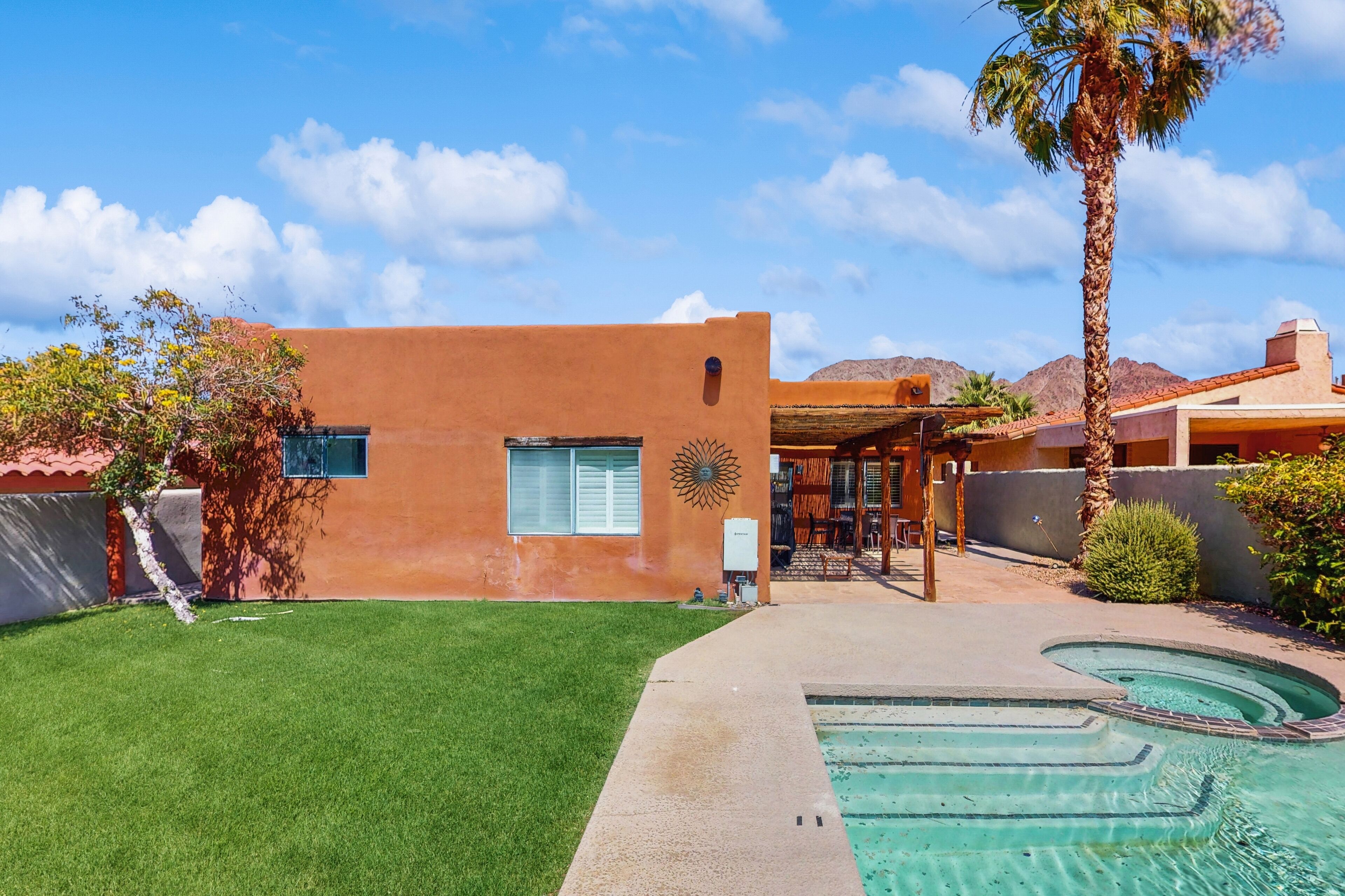 Une maison moderne dotée d’une piscine, d’une pelouse bien entretenue et offrant une vue sur les montagnes.