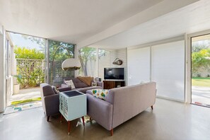 A modern living room with a sofa, coffee table, and TV. - Well-designed & modern villa with patios, pool & hot tub - walk to downtown (Palm Springs)