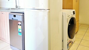 Una cocina funcional con lavavajillas, refrigerador y lavadora.