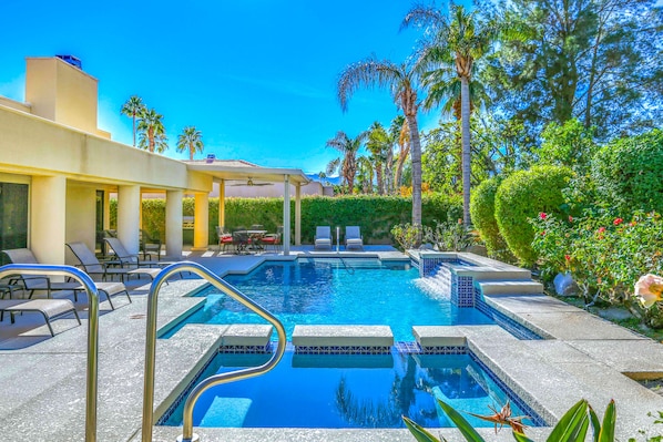 A swimming pool with lounge chairs and palm trees. - Desert oasis with gorgeous pool, attached spa & firepit - dog-friendly (Palm Desert)