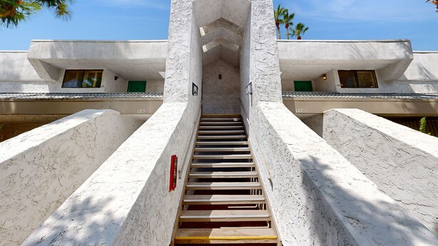 Un escalier menant à l’entrée d’un bâtiment dont l’architecture est particulièrement originale.