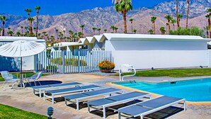 A pool area with lounge chairs, a pool, and a mountain backdrop. - Charming & bright mid-century condo with shared pool - Free WiFi (Palm Springs)